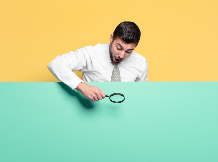 Foto joven empresario guapo con una lupa. concepto de búsqueda