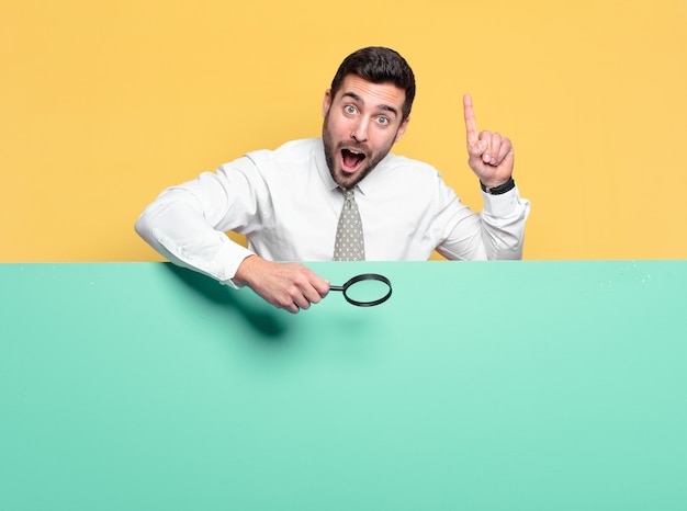 Foto joven empresario guapo con una lupa. concepto de búsqueda