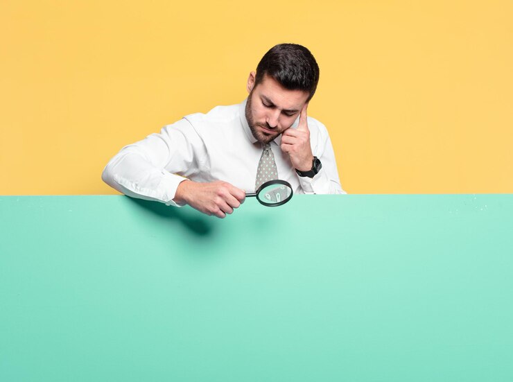 Foto joven empresario guapo con una lupa. concepto de búsqueda