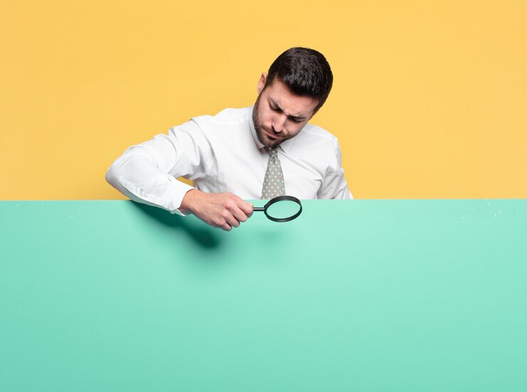 Foto joven empresario guapo con una lupa.