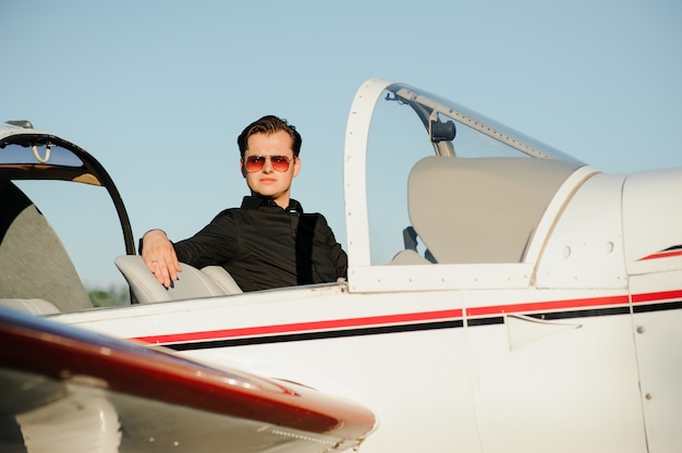 Joven empresario guapo de pie dentro del avión privado