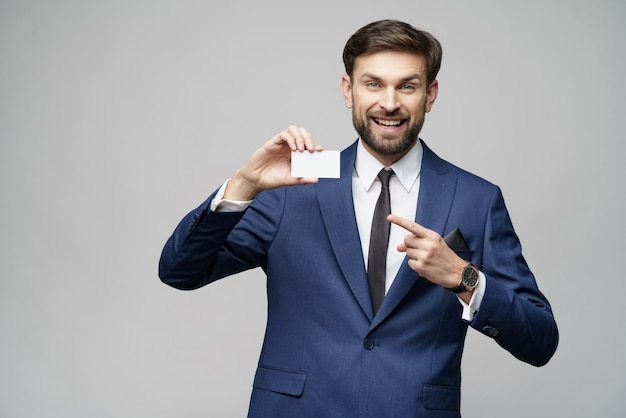 Joven empresario guapo con tarjeta de negocios o crédito