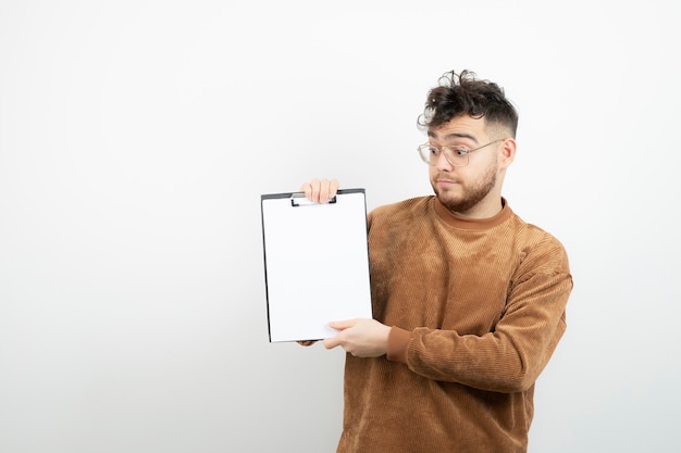 Foto joven empresario guapo en vasos con notas de pie.