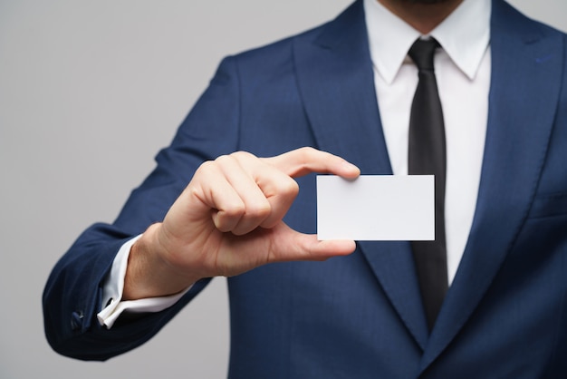 Foto joven empresario guapo vistiendo traje con tarjeta de visita