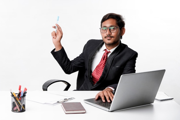 Joven empresario indio apuntando con la mano en la oficina