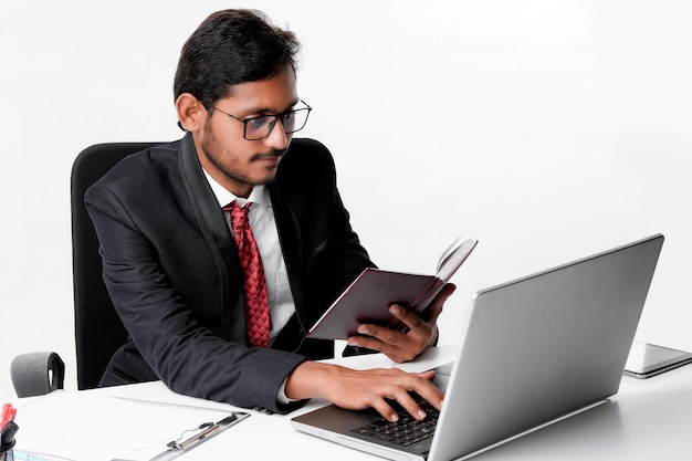 Joven empresario indio cheking o leyendo productos lácteos en la oficina.