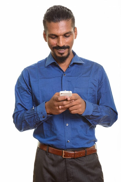 Joven empresario indio feliz mediante teléfono móvil aislado