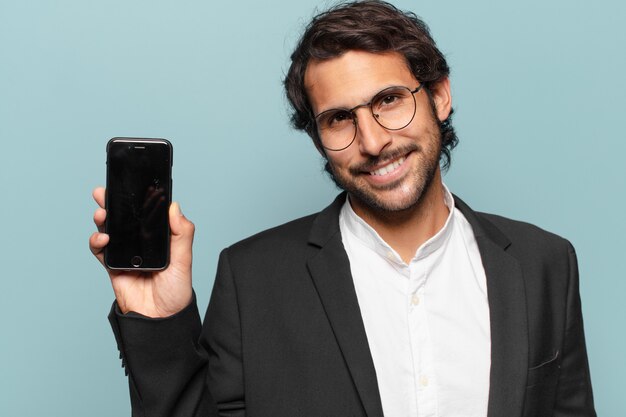 Joven empresario indio guapo mostrando su pantalla vacía de teléfono