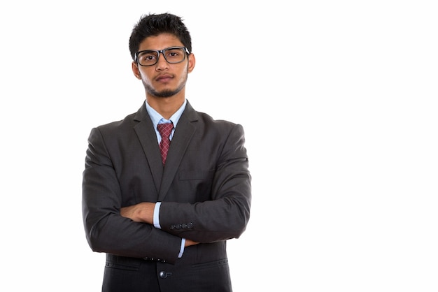 Joven empresario indio guapo posando con los brazos cruzados.
