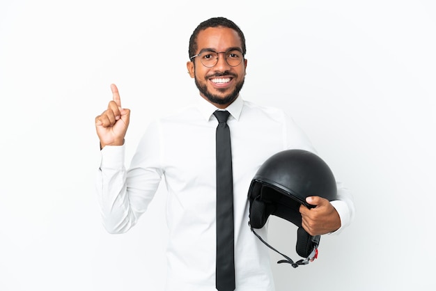 Joven empresario latino con un casco de motocicleta aislado sobre fondo blanco apuntando hacia una gran idea