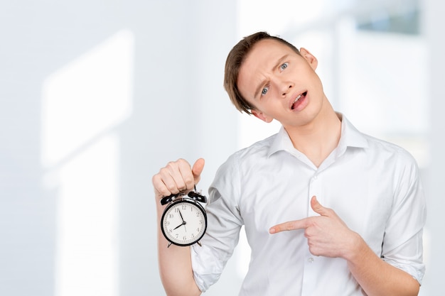 Joven empresario manteniendo el reloj