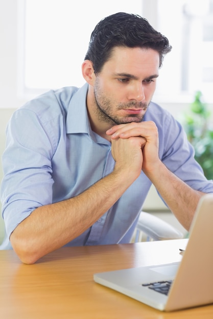 Joven empresario mirando portátil