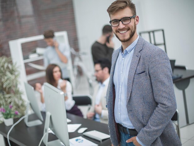 Joven empresario moderno en el fondo de los empresarios del lugar de trabajo