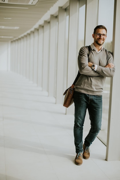 Joven empresario moderno de pie en el pasillo de la oficina