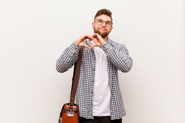 Joven empresario moderno sonriendo y mostrando una forma de corazón con él las manos