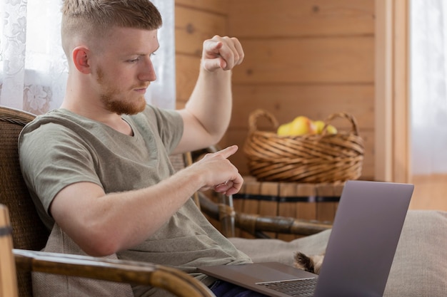 Joven empresario participa en una reunión con colegas a través de Internet utilizando una computadora portátil de forma remota desde casa