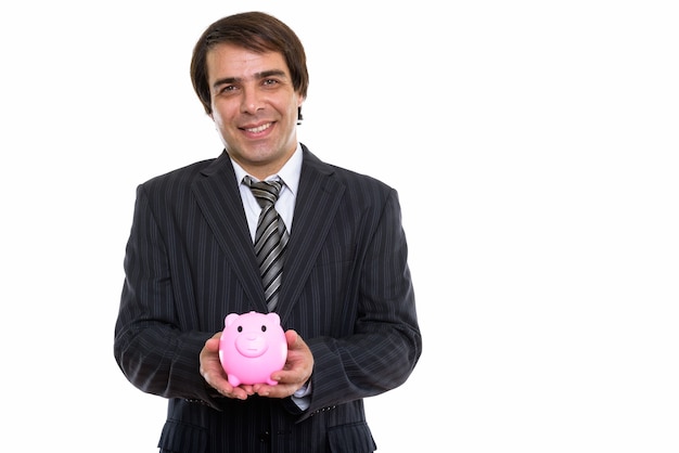 Joven empresario persa feliz sonriendo mientras sostiene una alcancía