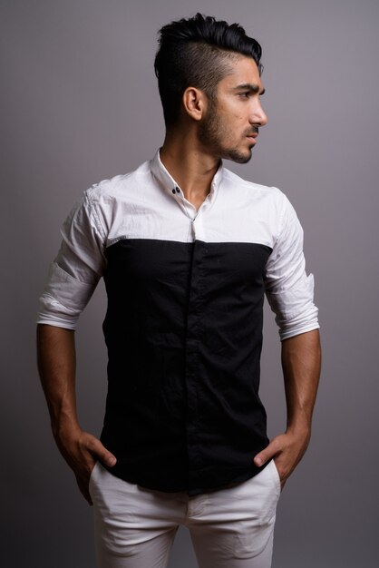 Foto joven empresario persa guapo contra el fondo gris