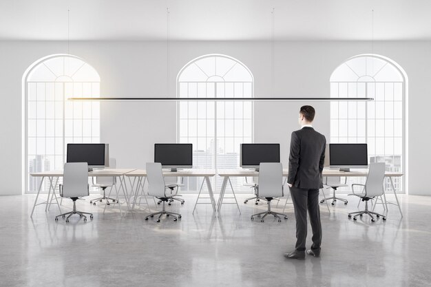 Joven empresario de pie en la oficina de coworking