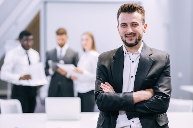 Joven empresario de pie en la oficina moderna mostrando confianza a