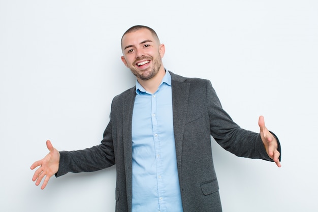 Joven empresario que parece feliz, arrogante, orgulloso y satisfecho de sí mismo, sintiéndose como el número uno contra la pared plana