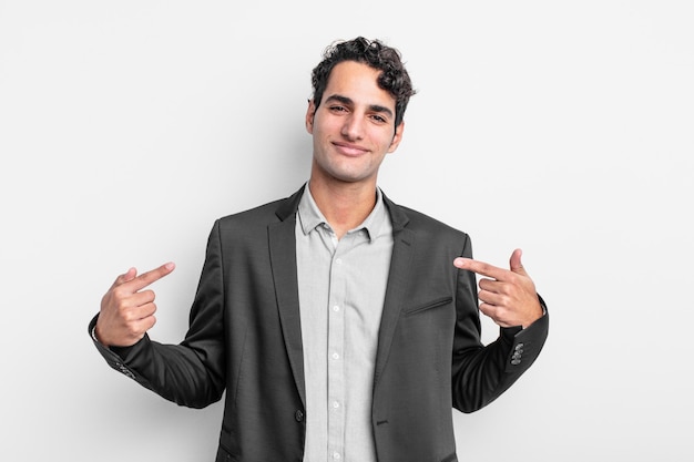 Joven empresario que parece orgulloso, arrogante, feliz, sorprendido y satisfecho, apuntando a sí mismo, sintiéndose como un ganador