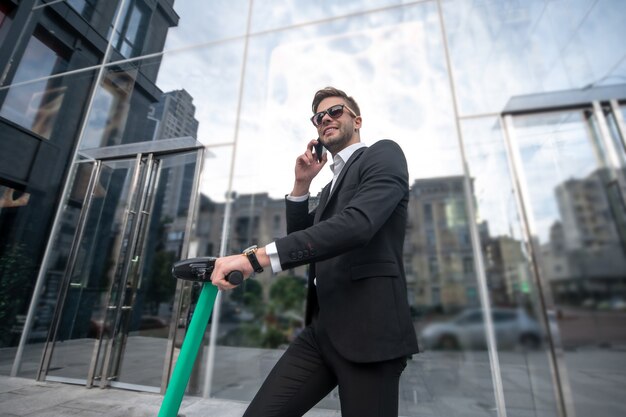 Joven empresario con el scooter en la calle