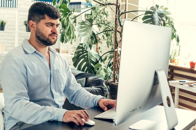 Joven empresario sentado en su mesa de trabajo en la oficina