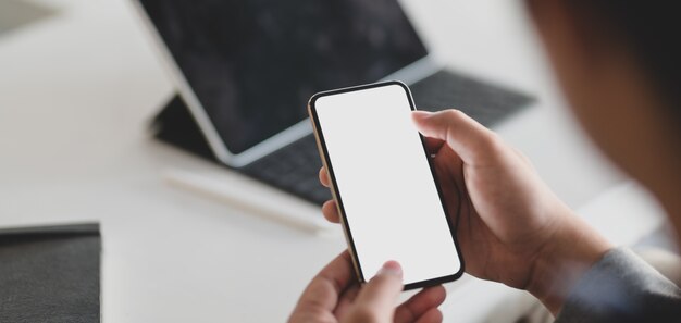 joven empresario con smartphone de pantalla en blanco