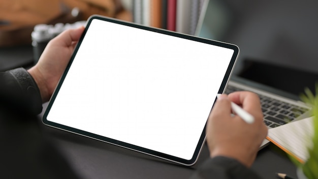 joven empresario con tableta digital de pantalla en blanco en la oficina moderna