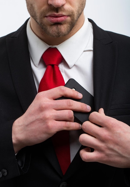 Foto joven empresario con teléfono, corbata roja con traje y oeste, negocios.