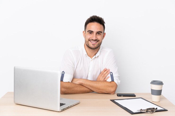 Foto joven empresario con un teléfono móvil en un lugar de trabajo riendo