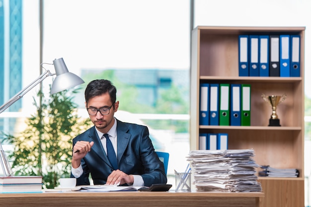 Joven empresario en tensión con mucho papeleo