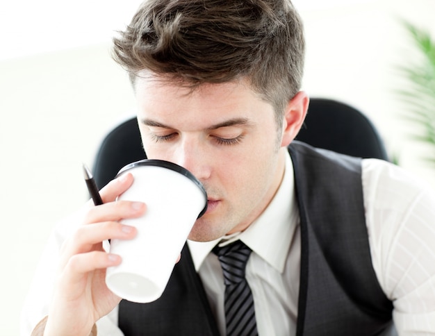 Joven empresario tomando café en la oficina