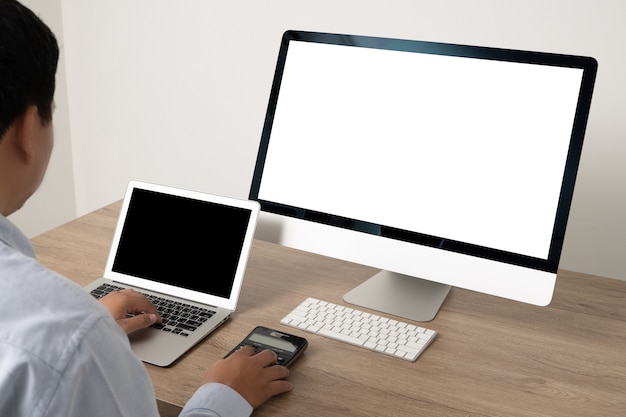 Joven empresario de trabajo usando una computadora de escritorio de la pantalla en blanco