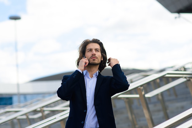 Joven empresario en traje completo de pie al aire libre