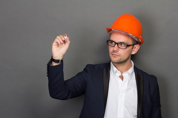 Joven empresario usar un casco de seguridad, escribiendo