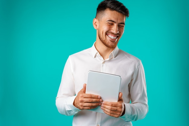 Joven empresario vistiendo camisa blanca tiene tableta digital