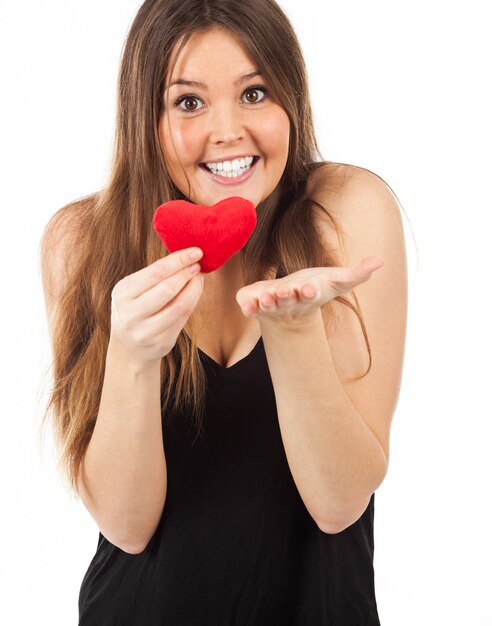 Joven enamorada con un corazón en la mano