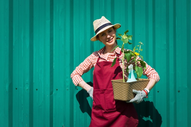 Una joven y encantadora floristería sonriente arreglando plantas en una floristería, el hobby se ha convertido en un pequeño