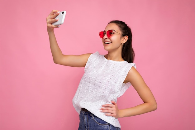 Joven encantadora hermosa mujer morena sonriente feliz con emociones sinceras vistiendo blanco de moda