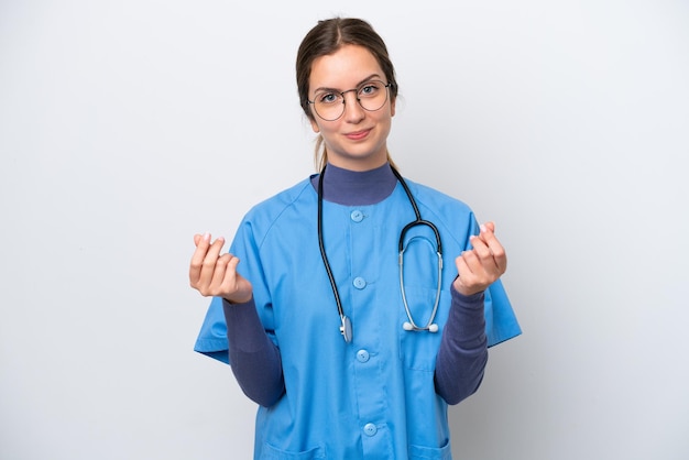 Joven enfermera caucásica mujer aislada sobre fondo blanco haciendo gesto de dinero