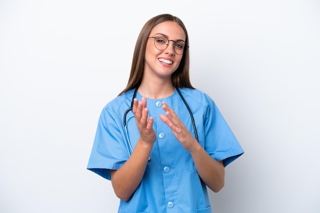 Foto joven enfermera mujer caucásica aislada de fondo blanco aplaudiendo después de la presentación en una conferencia