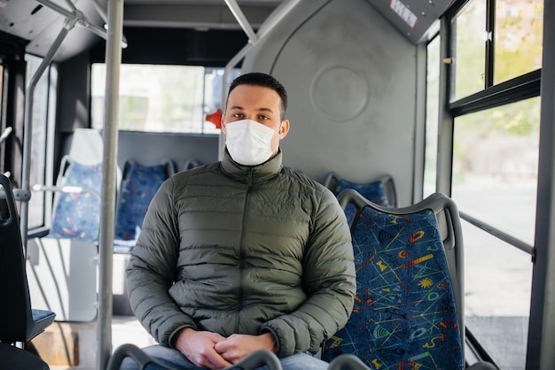 Un joven enmascarado usa el transporte público solo durante una pandemia. Protección y prevención covid 19.