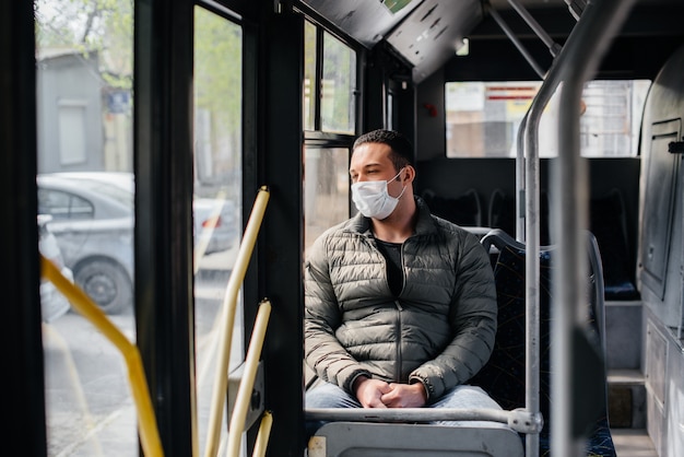 Un joven enmascarado usa el transporte público solo durante una pandemia. Protección y prevención covid 19.