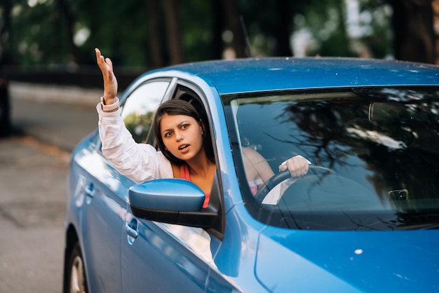 Una joven enojada se asoma por la ventana del auto