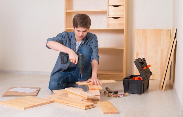 Joven ensamblando muebles en casa