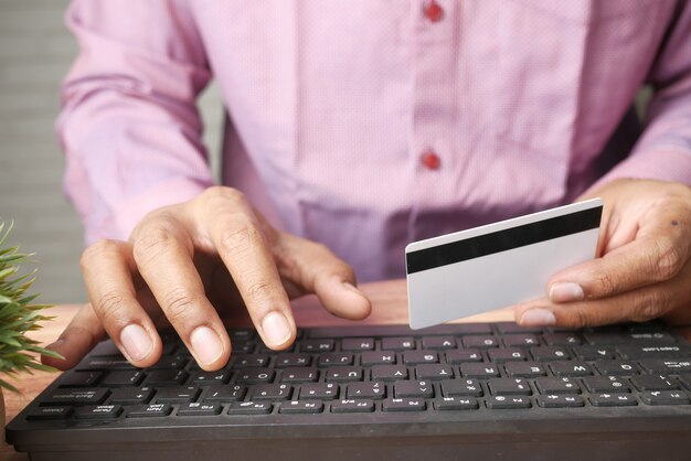 Joven entrando en la tienda de detalles de tarjeta de crédito online