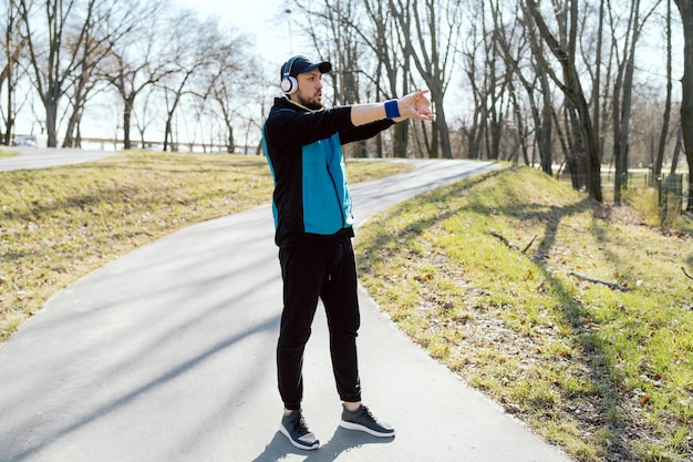 Un joven entrena en un parque público escuchando música motivacional