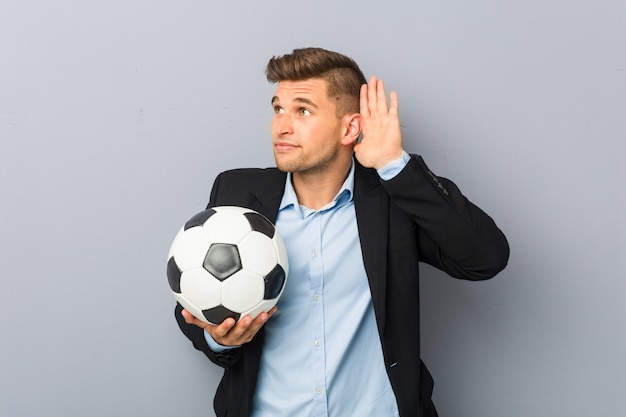 Foto joven entrenador de fútbol tratando de escuchar un chisme.